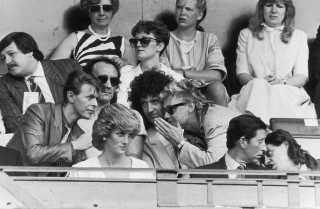 Live Aid Concert in Wembley Stadium (1985) features The Princess and Prince of Wales, Bob Geldof, David Bowie, and Queen members.