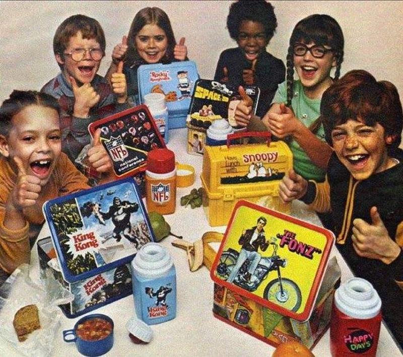 Children in the 1970s delightedly flaunting their lunchboxes.