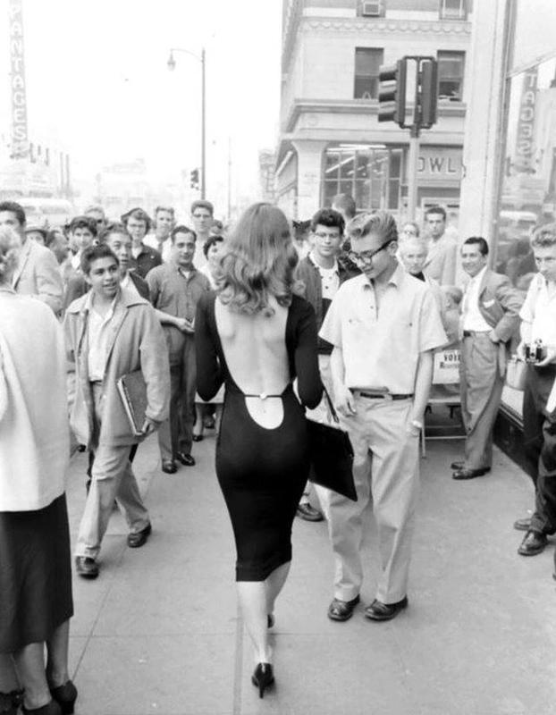 1950s Model Vikki Dougan struts down the sidewalk, turning it into her personal catwalk.