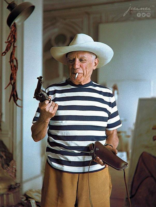 Pablo Picasso, adorned with a hat, showcases revolver and holster presented by Gary Cooper at Cannes in 1958
