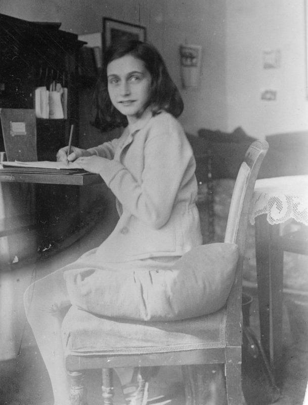 Anne Frank at desk in Amsterdam apartment, 1941.