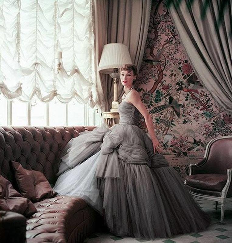Model Sophie Malgat showcases the latest 'big' ball gown from Christian Dior's collection, featuring a 12-layered skirt, in the sun room of his Parisian residence. (1953)