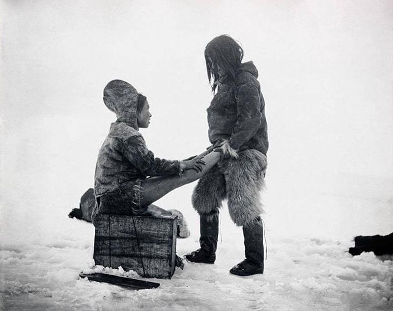 In Greenland during the 1890s, an Inuit man tenderly warms his wife's feet.