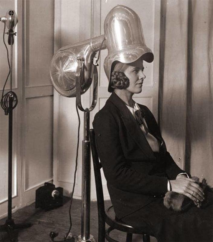 In 1928, relaxing beneath a shiny chrome hair dryer.