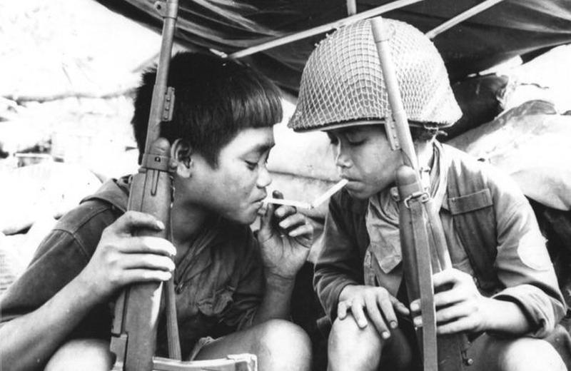 Child soldiers from South Vietnam form a bond while sharing a cigarette.