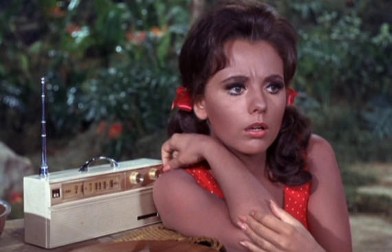 Dawn Wells sporting rolled-up shorts and a tied blouse, eagerly prepares to dip her toes in the lagoon.