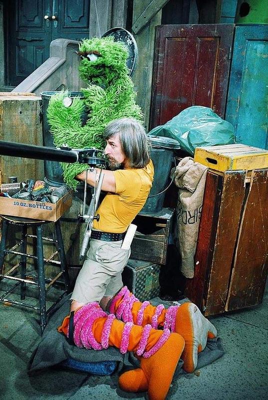 Caroll Spinney, known for portraying 'Big Bird' and 'Oscar the Grouch' on 'Sesame Street,' shown multitasking on the set in the 1970s.