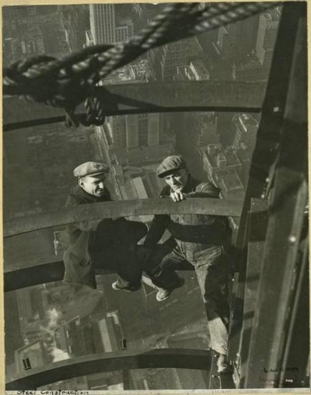 Two workers marvel at their accomplishments from 1,000 feet in the air on the Empire State Building